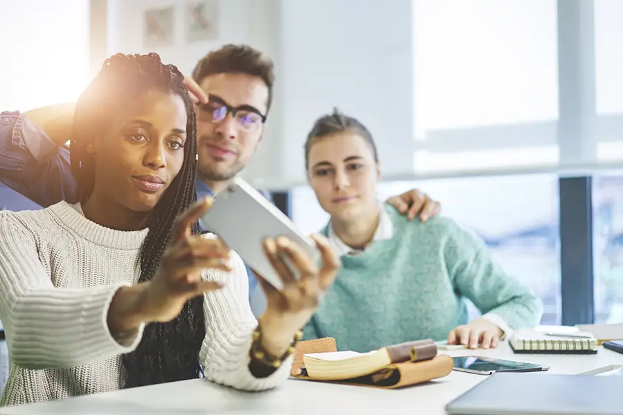 Multiple coworkers pose for a selfie at work.