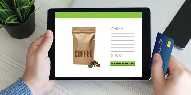 A man swipes his credit card on a tablet.