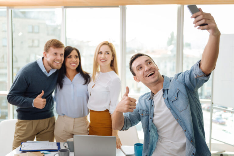Several employees pose for a selfie