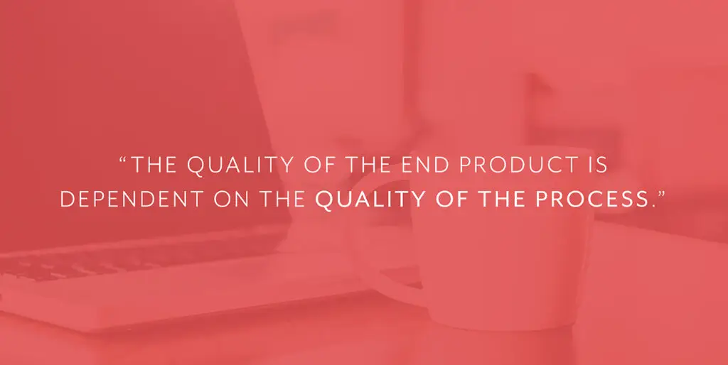 A coffee cup sits next to a laptop with white font that reads, "The quality of the end product is dependent on the quality of the process."