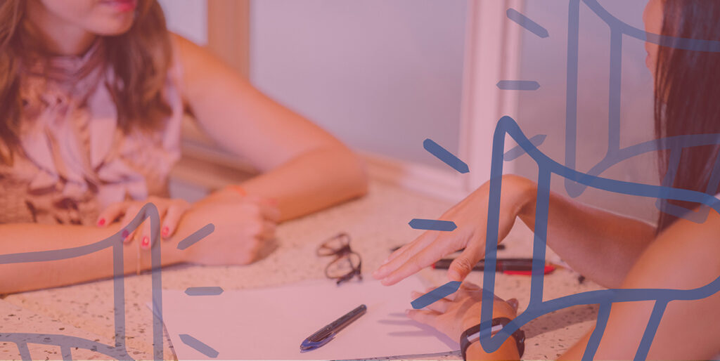 Two woman discuss business at a table