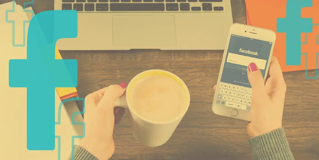 A woman holds an iPhone displaying the Facebook log in screen