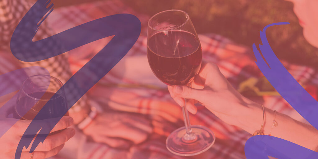 Two people relax with wine on a blanket at ArtPrize in Grand Rapids