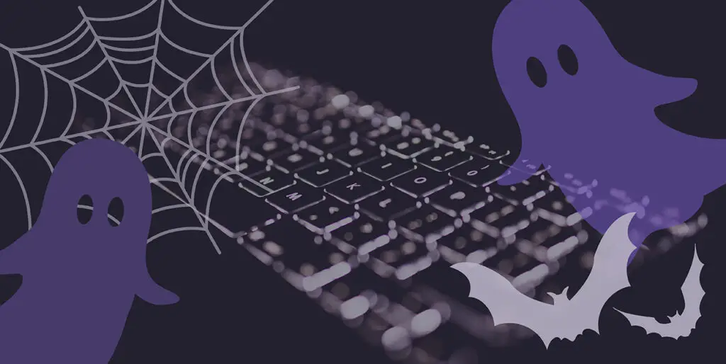 A black keyboard with cartoon ghosts, bats, and a spiderweb superimposed over it.