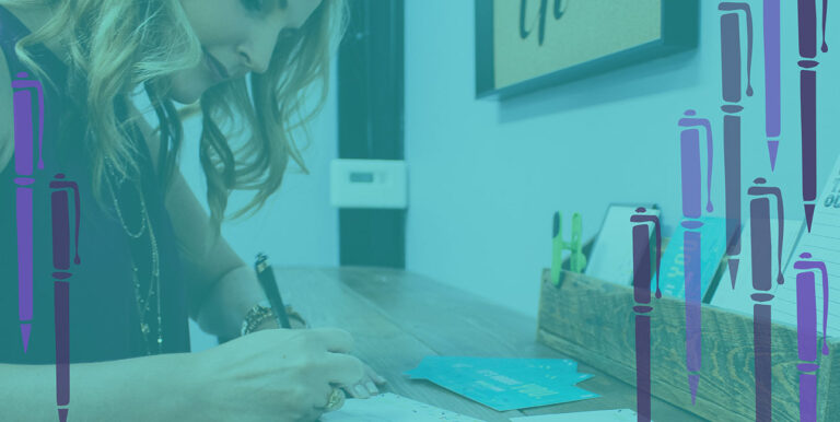 Sarah Abel writes a letter at a standing desk in the 8THIRTYFOUR office