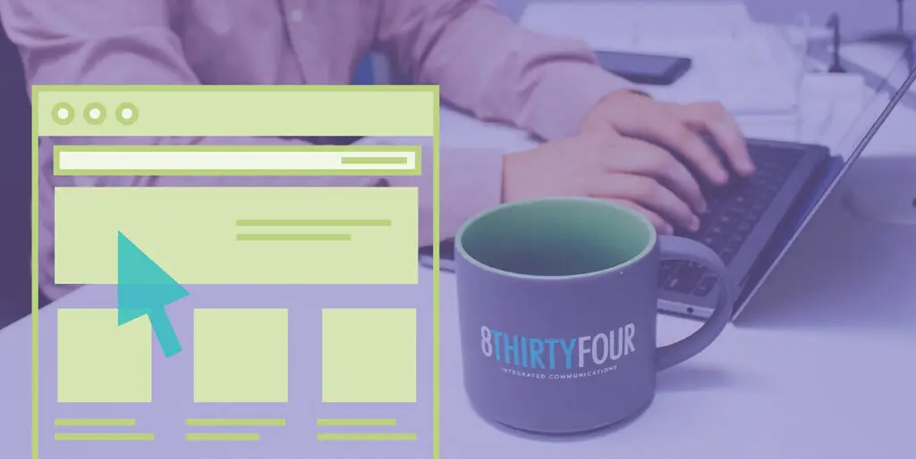 An employee working on a laptop with a mug in front of them that says, "8THIRTYFOUR Integrated Communications"