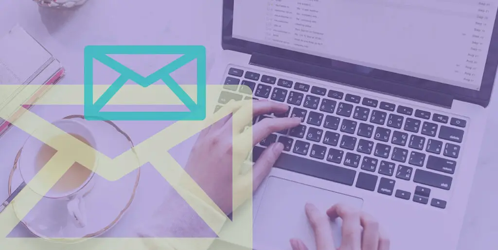 Someone typing on a laptop with two email symbols superimposed over the image