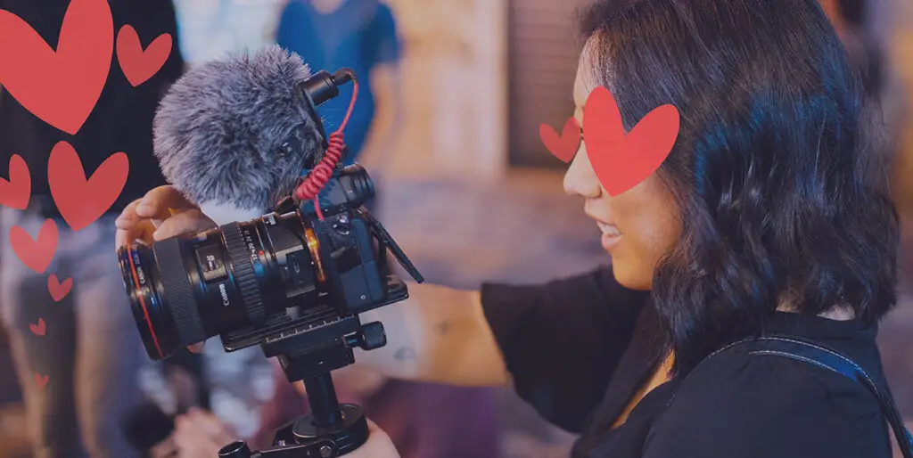 A camera person records a television segment while she has hearts over her eyes.