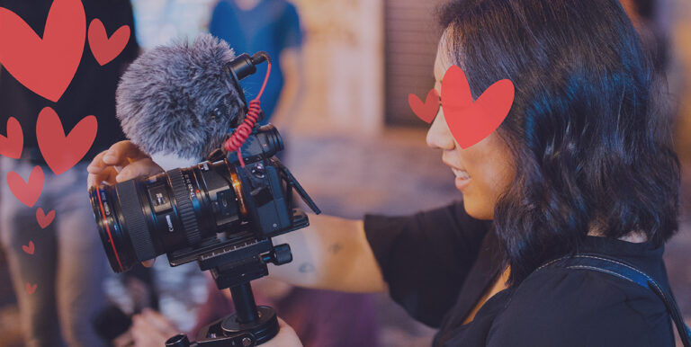 A camera person records a television segment while she has hearts over her eyes.