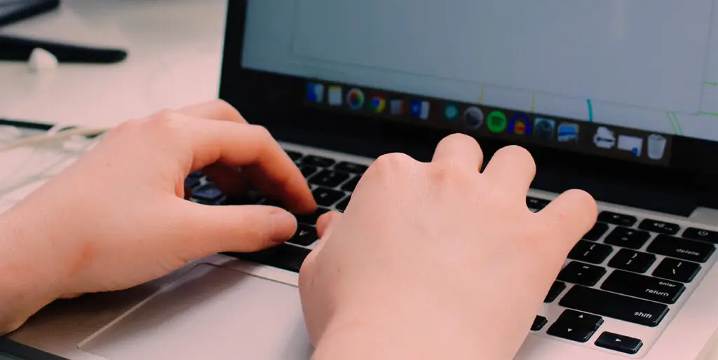 Rowan Leo types on their laptop inside of the 8THIRTYFOUR office.