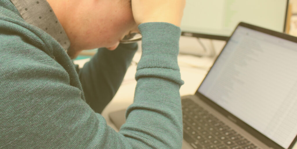 Digital Director Kayden Grinwis buries his face in his hands while working at the 834 office in Grand Rapids, Michigan.