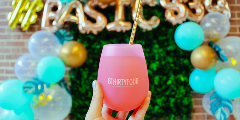 A photo of an 8THIRTYFOUR branded cup against a backdrop at the 8THIRTYFOUR Basic Party in Grand Rapids, Michigan.