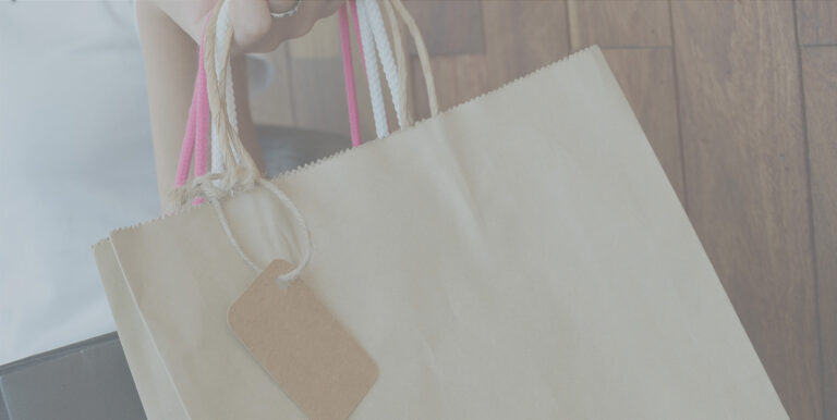 An image of a shopping bag with a pink handle.
