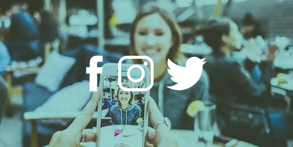 A photo of someone taking a photo of another person in a crowded restaurant. Facebook, Instagram and Twitter icons are placed on top of the photo.