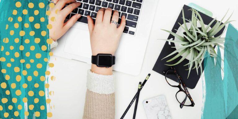 A person wearing a cuff bracelet and a watch, typing on a laptop. A pad of paper with a plant on top, and some eyeglasses and pens, lay next to it.