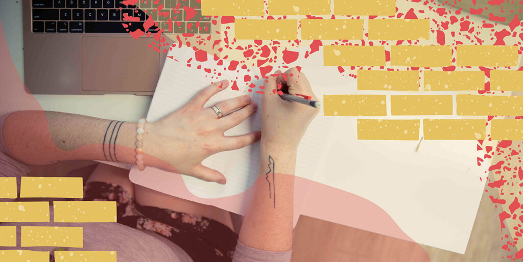 An overhead image of a person writing in a notebook.