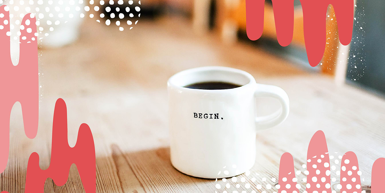 A coffee mug with the word "Begin" on it placed on a table.