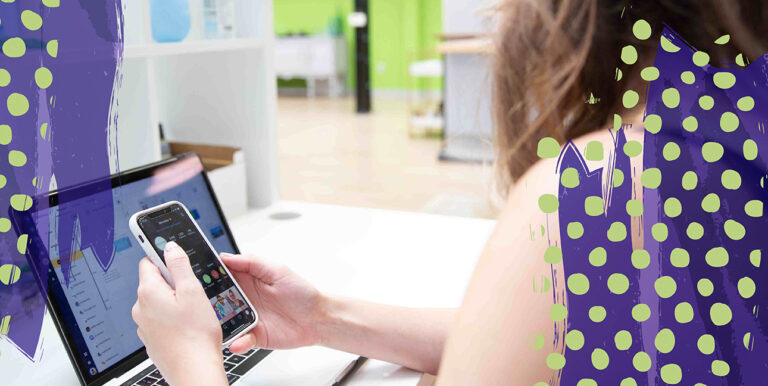 Someone typing on a phone in front of an iPad.