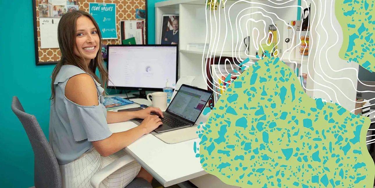 A woman sitting at her desk, typing on a laptop
