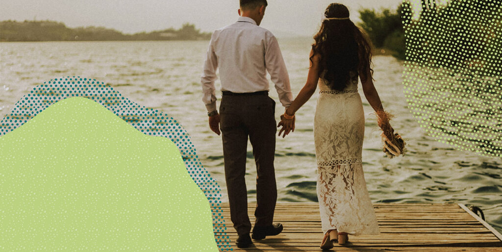 a couple holding hands and walking on a dock