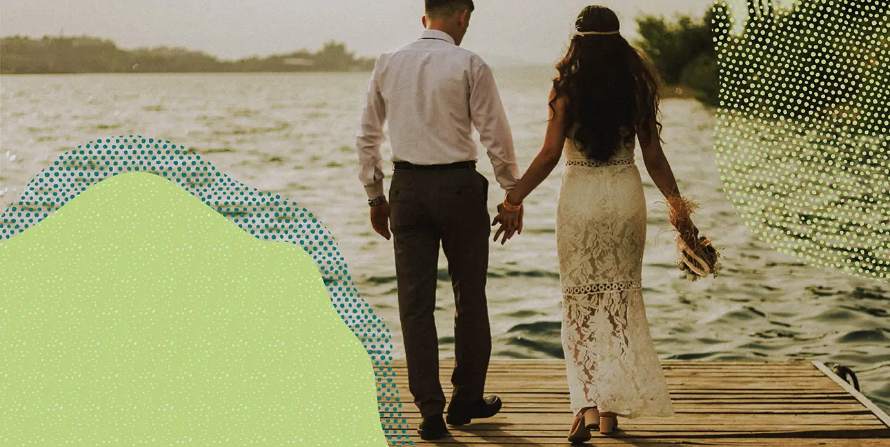a couple holding hands and walking on a dock