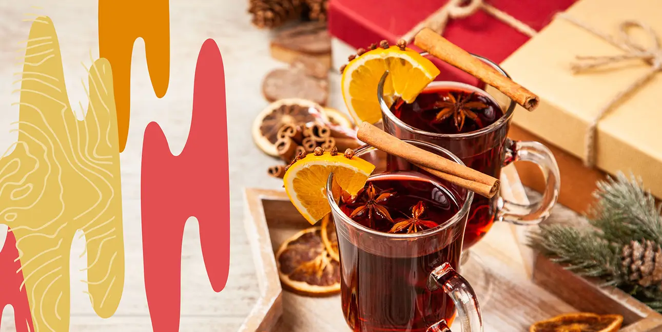 holiday cocktails garnished with orange and cinnamon.