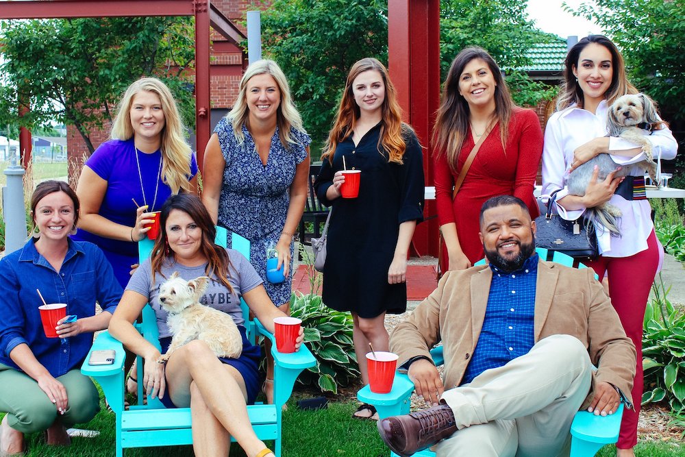 a group of people outside in a park having a drink