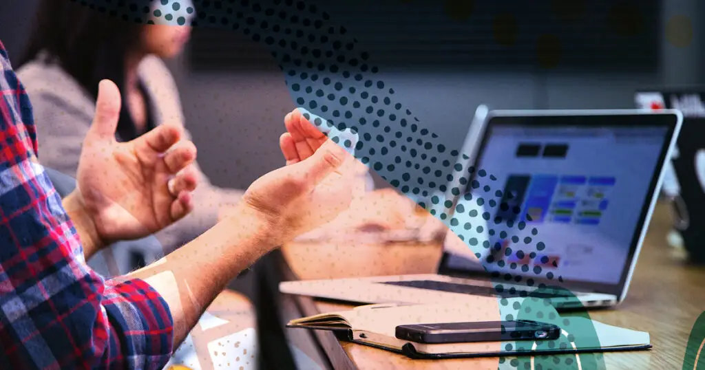 Man talking with his hands with a computer open