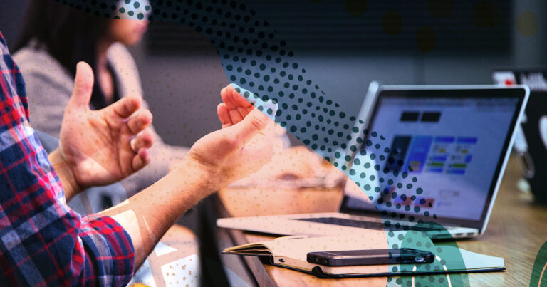 Man talking with his hands with a computer open