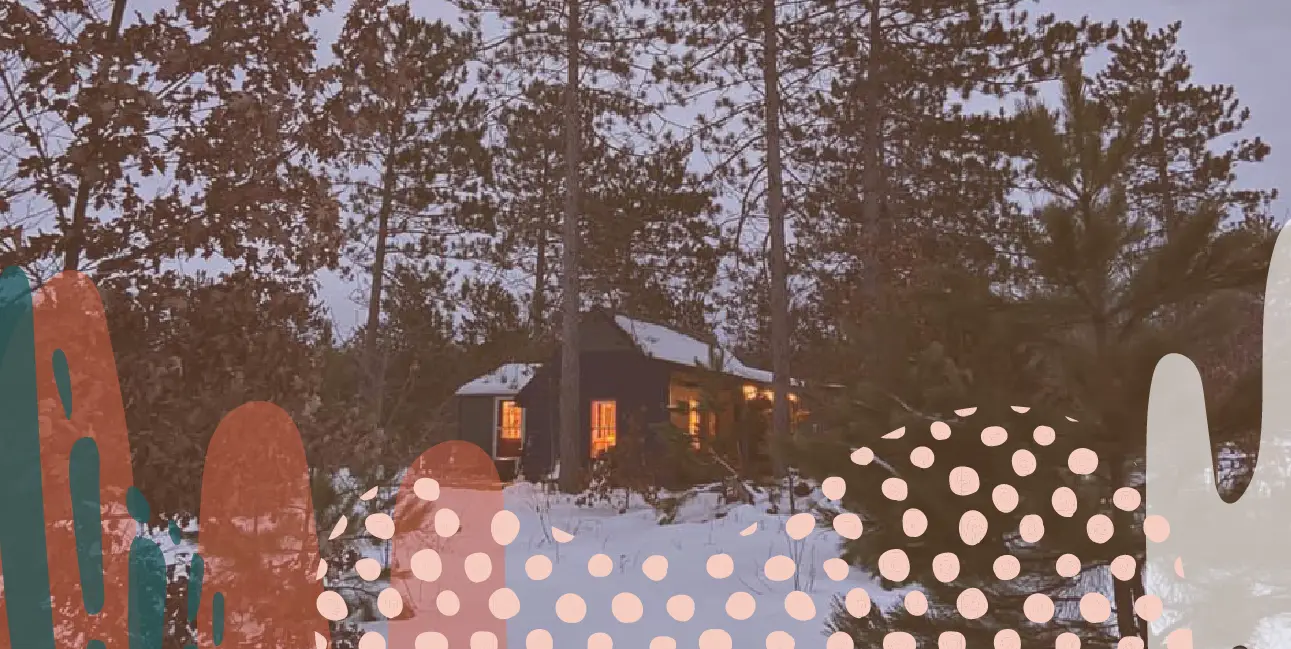 Cabin in the woods surrounded by snow and pine trees