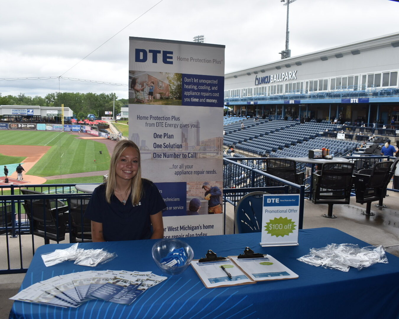 DTE Home Protection Plus booth at a home Whitecaps game with a someone sitting at the table working