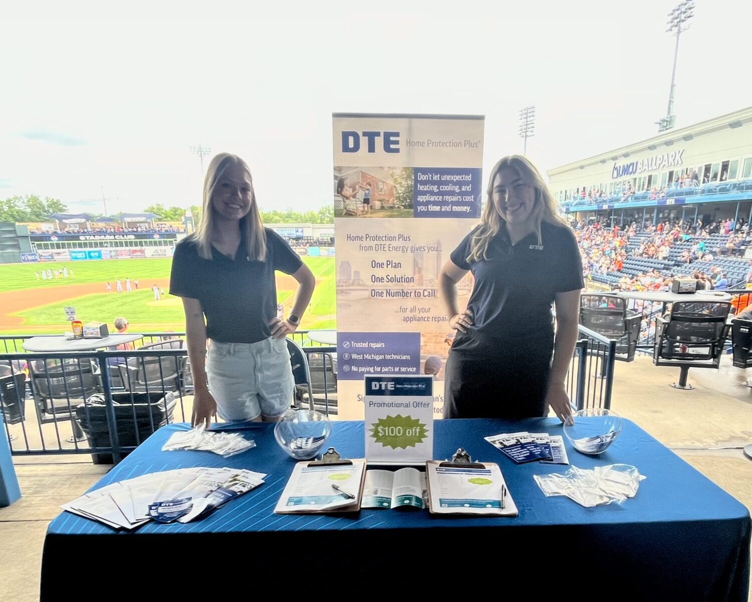 The DTE Home Protection Plus booth at a Whitecaps game with two people working it