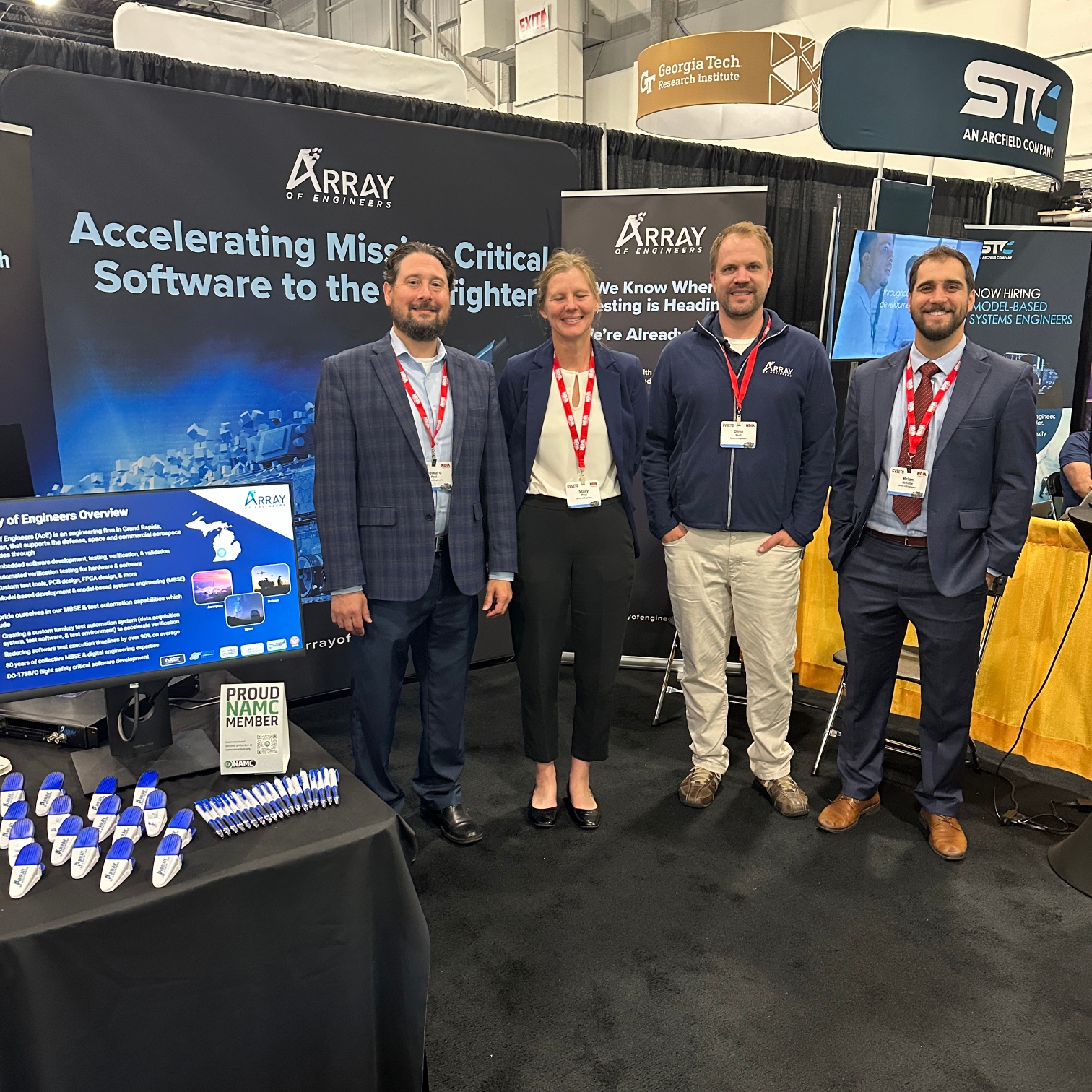 Array of Engineers team members pose at their booth at GVSETS