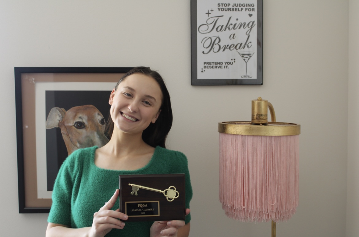 Amberly Dzimira posing with a PRSSA award.