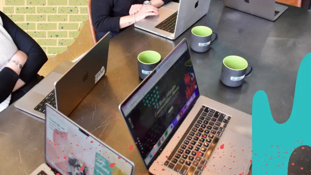 A group of people work together on their laptops at 8THIRTYFOUR.