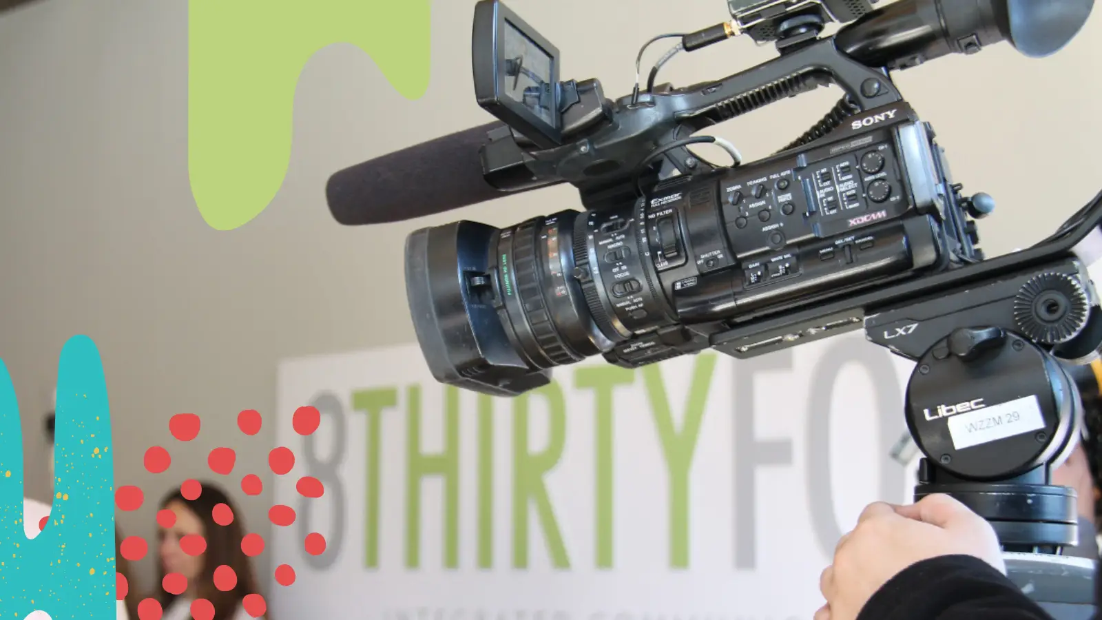 A local news camera films in front of the 8THIRTYFOUR sign.