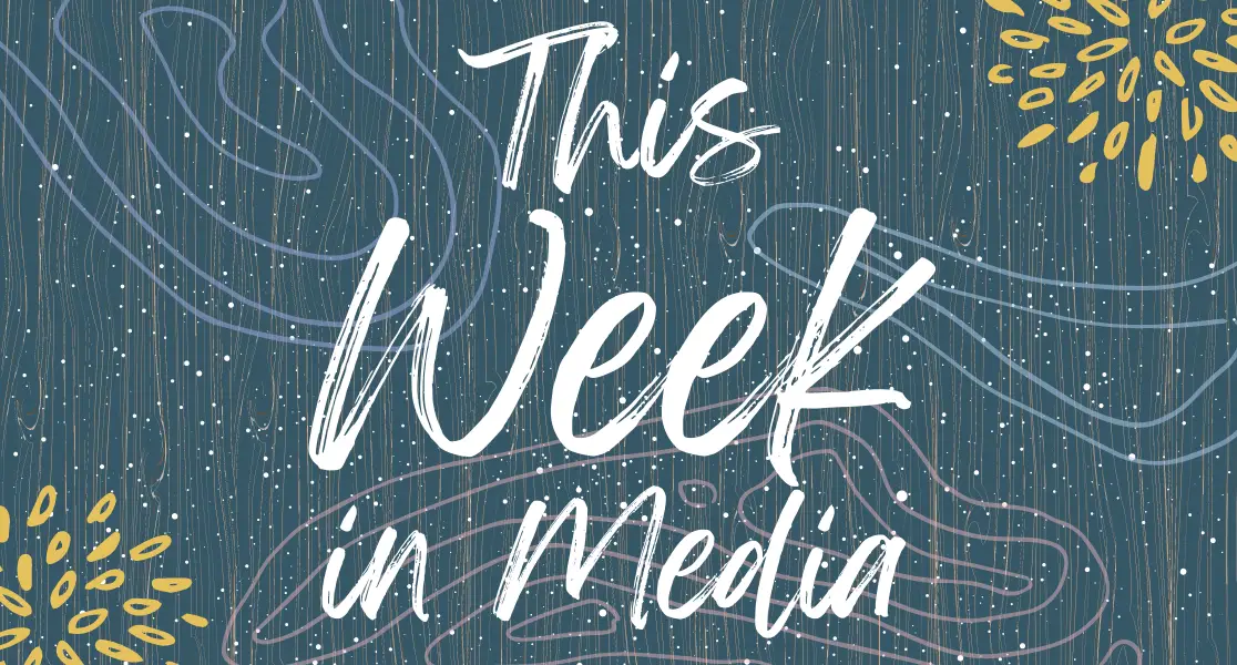 This week in media sign with a blue background and white lettering. With yellow flowers in the corners