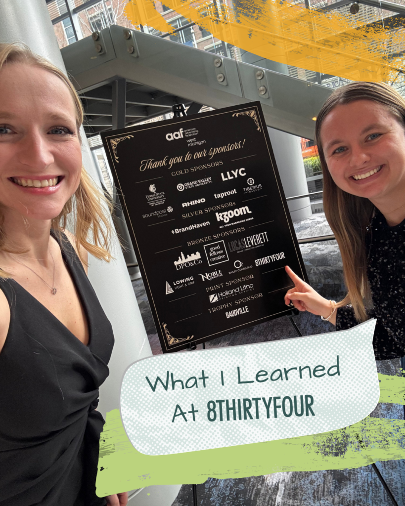 Abby Wettlaufer and Maddie Odle smile in front of the AAF Addy awards sign.