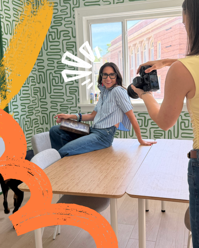 Woman smiling on a table while someone takes a photo of her