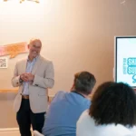 Man smiling during presentation.