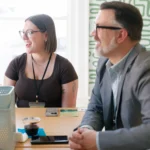 two people smiling in a meeting.