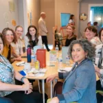 A group of women sit around a table in the 8THIRTYFOUR Learning Hub.