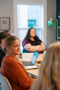 women at a table listening to a talk