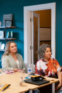 two women sitting down listening