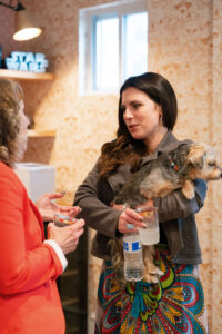 women holding a dog talking to another woman