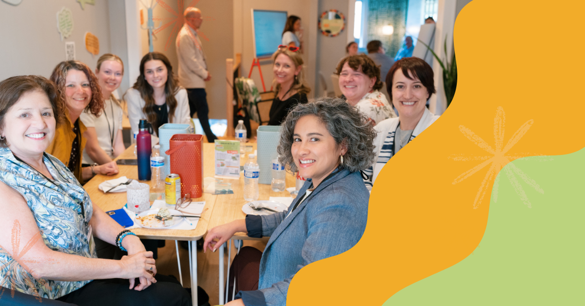 A table of smiling women at an event.